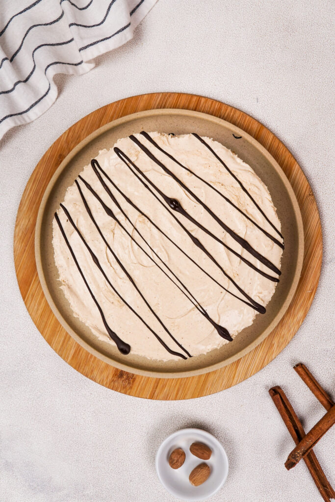 Gluten-Free No-bake Cheesecake on a serving plate decorated with drizzles of chocolate.