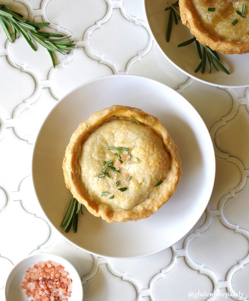 A Gluten-Free Chicken Pot Pie topped with salt and rosemary on a white plate
