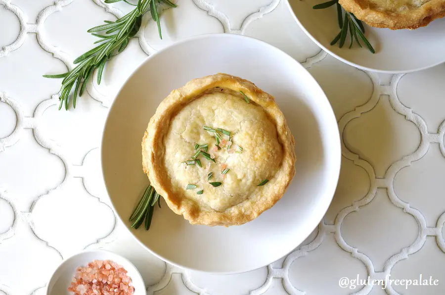 a close up of A Gluten-Free Chicken Pot Pie topped with salt and rosemary on a white plate