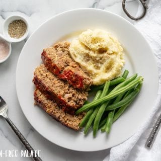 sliced Gluten-Free Meatloaf on a white plate with mashed potatoes and green beans