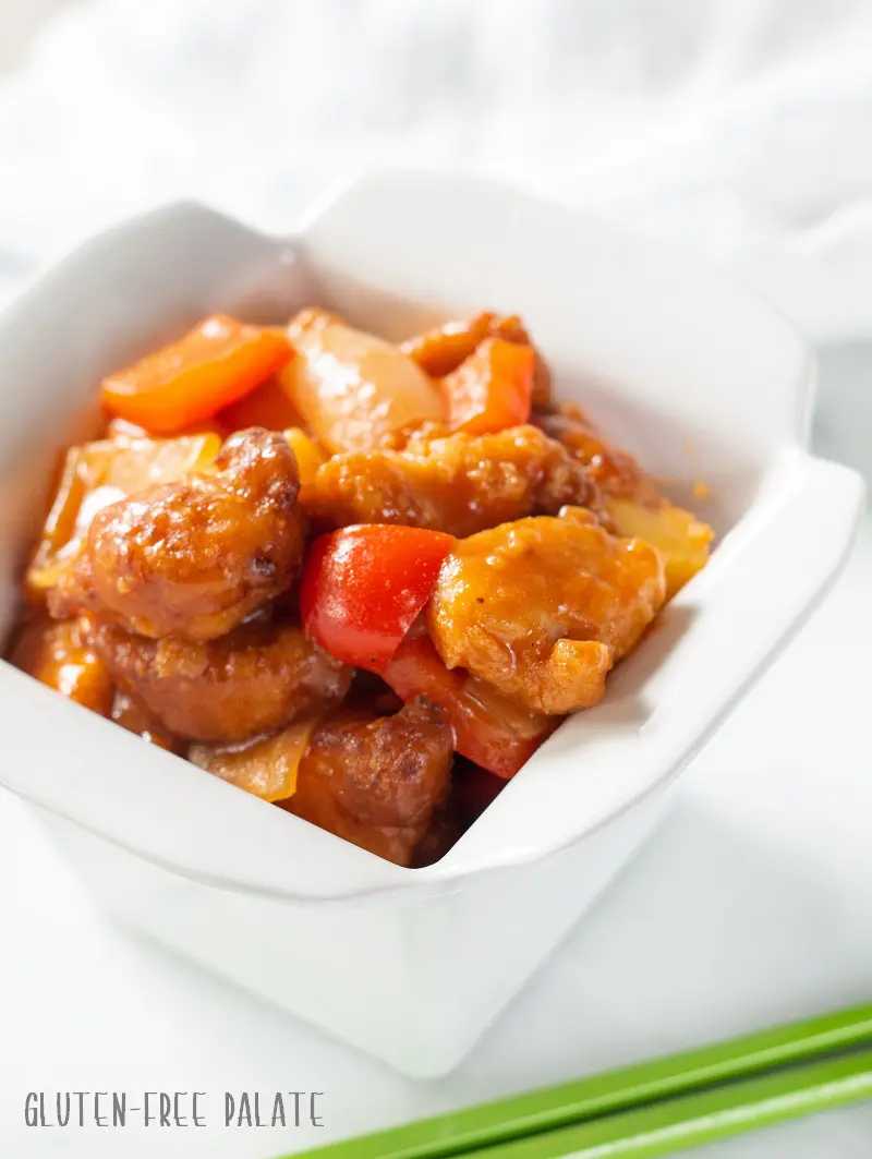 side view of Gluten Free Sweet and Sour Chicken in a white dish