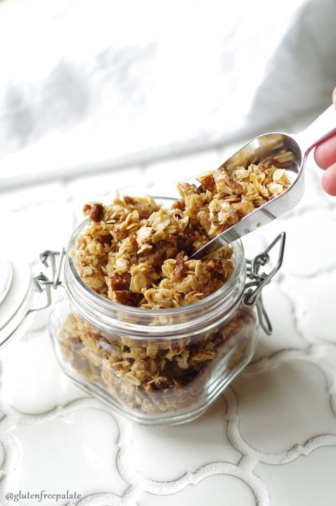 Gluten-Free Granola in a glass jar with a scoop.