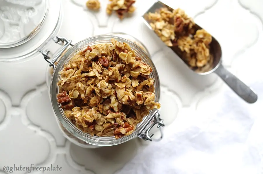 Gluten-Free Granola in a glass jar with a scoop with granola next to it