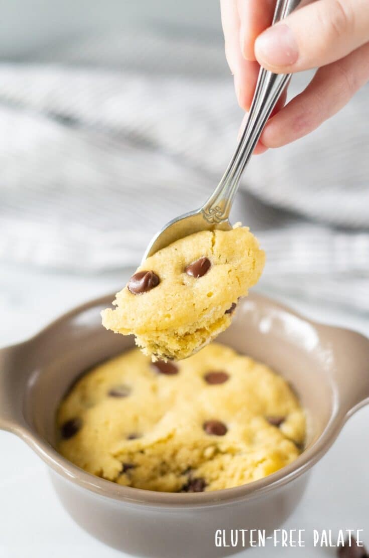 Gluten Free Chocolate Chip Mug Cookie with a spoon taking a bite out