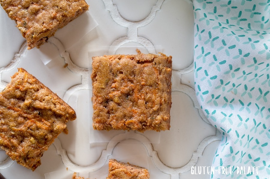 square carrot cake bars on a white background with a blue napkin
