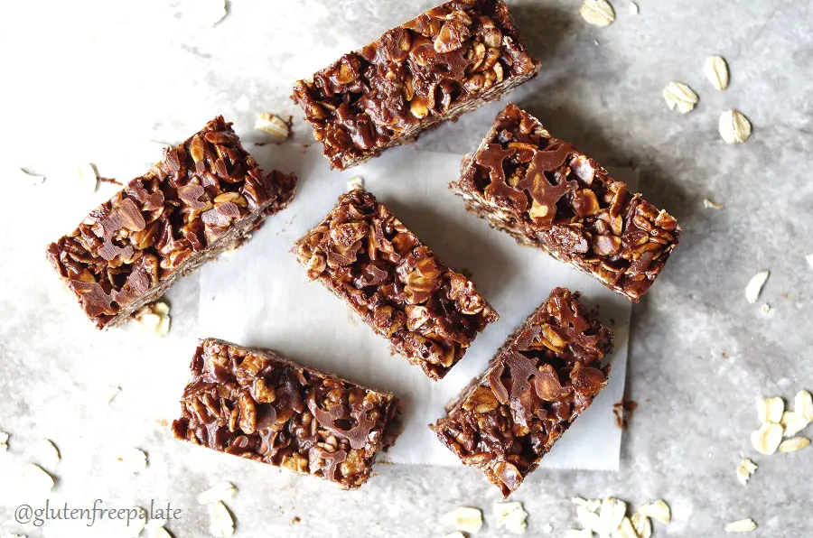 six chocolate oat bars with scattered oats around them