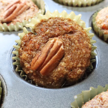 Paleo carrot cake muffins cooling in a muffin tin after baking.