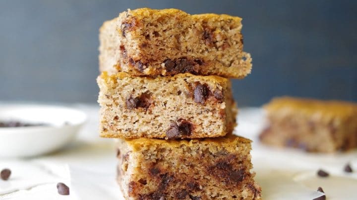 a close up of three paleo banana bars with chocolate chips stacked