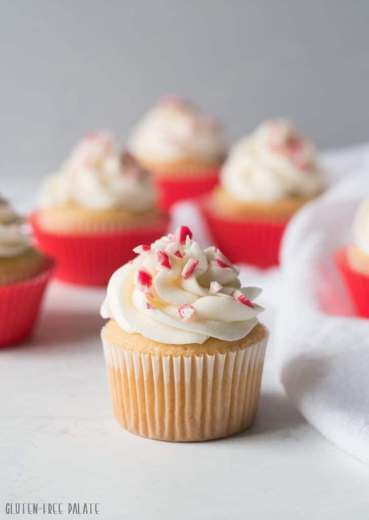 a cupcake topped with white frosting and candy cane pieces