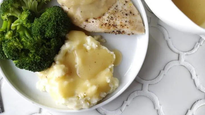 Gluten-Free Five Minute Gravy on chicken and potatoes on a plate with broccoli on a white plate