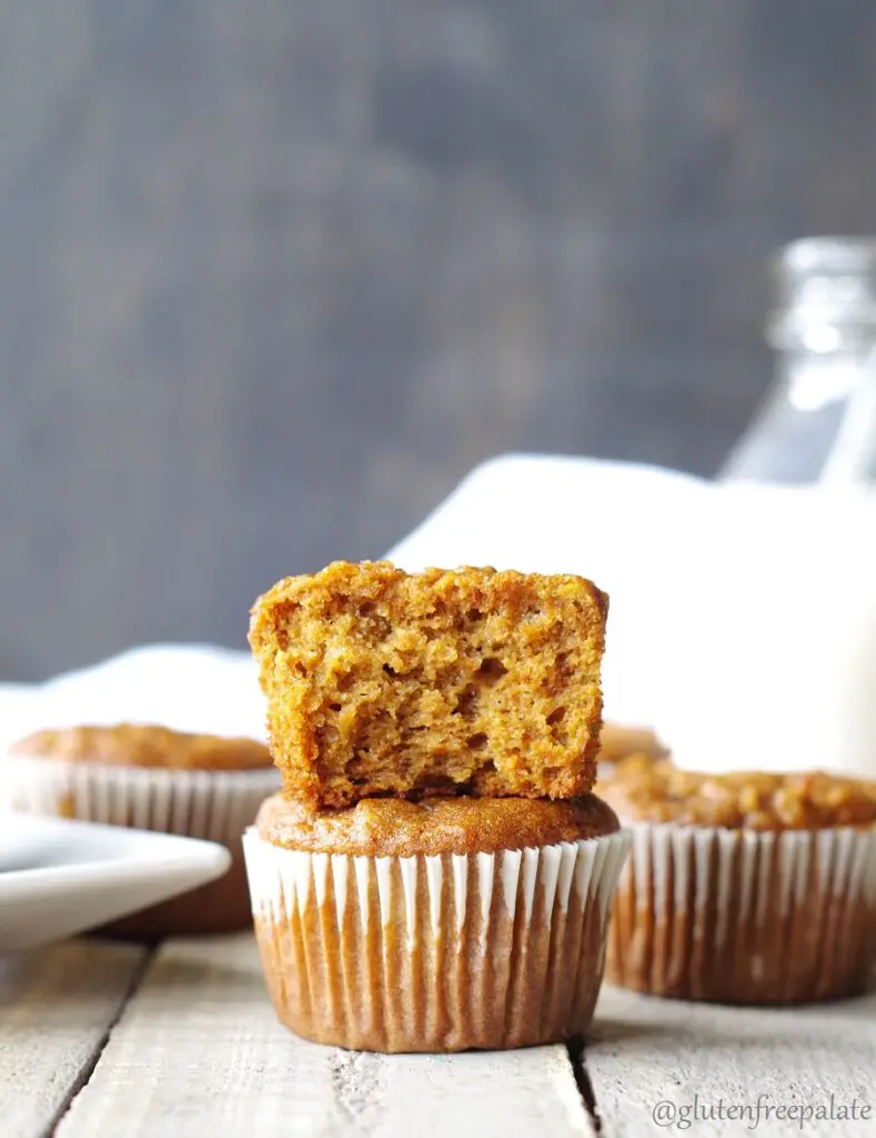 two gluten-free apple muffins stacked, the top muffin has a bit out to show the texture