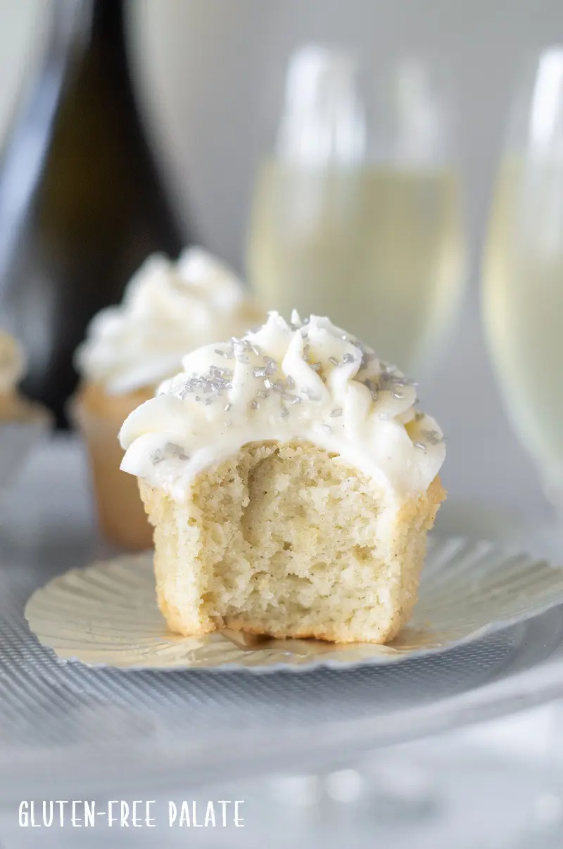 Gluten Free Champagne Cupcakes with silver sprinkles, with a bite out