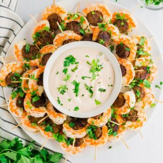 gluten-free sausage and shrimp on toothpicks around a bowl of dipping sauce