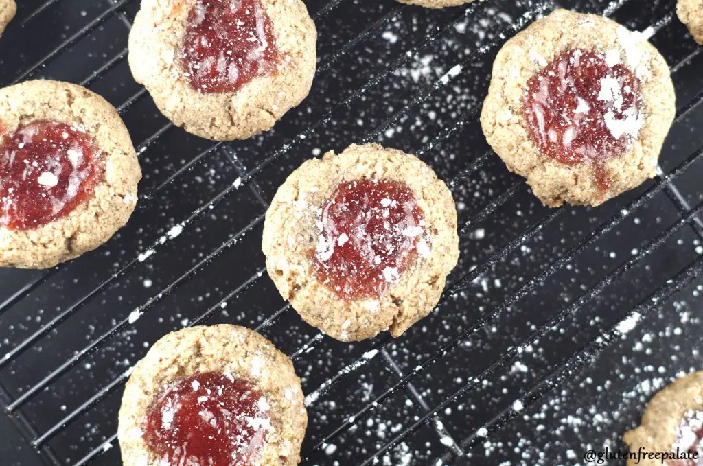 a top down view of paleo strawberry thumbprint cookies on a wire cooling rack