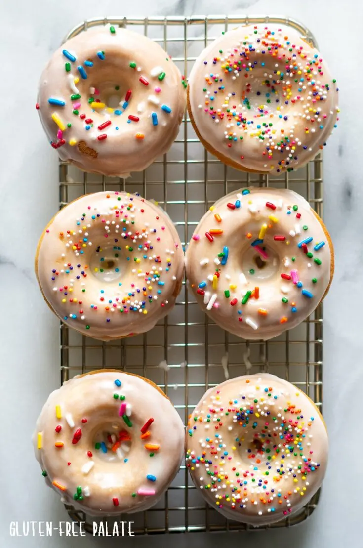 six gluten free donuts with glaze and sprinkles