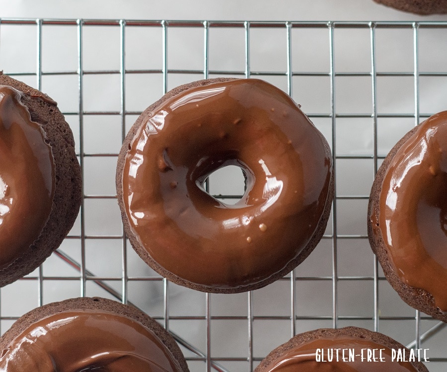 close up of some Gluten-Free Vegan Chocolate Espresso Donuts on a wire cooling rack.
