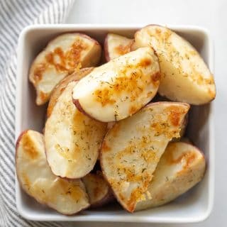 Cooked Red Roasted Potatoes in a white bowl with a striped napkin.