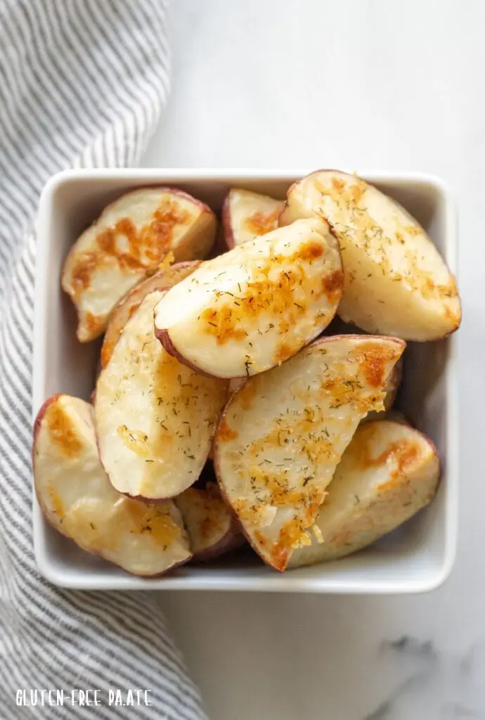 Cooked Red Roasted Potatoes in a white bowl with a striped napkin.
