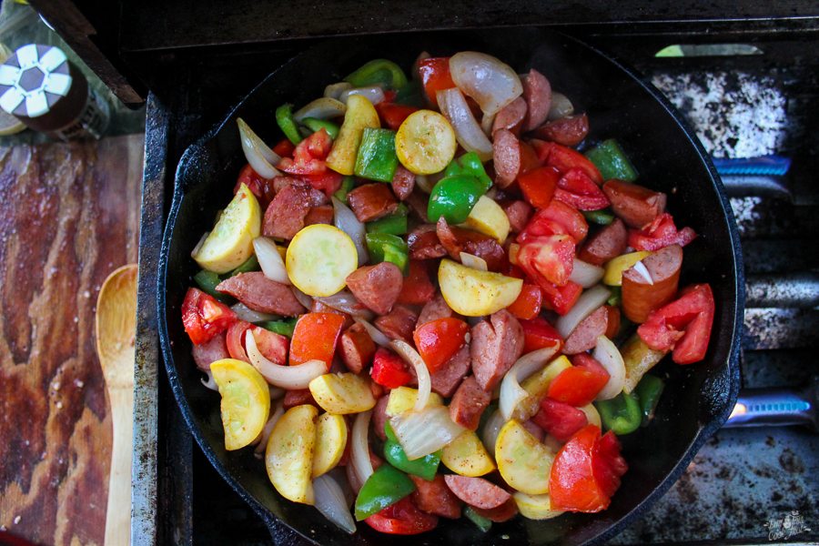 a top down view of a pan of vegetables and sliced sausages