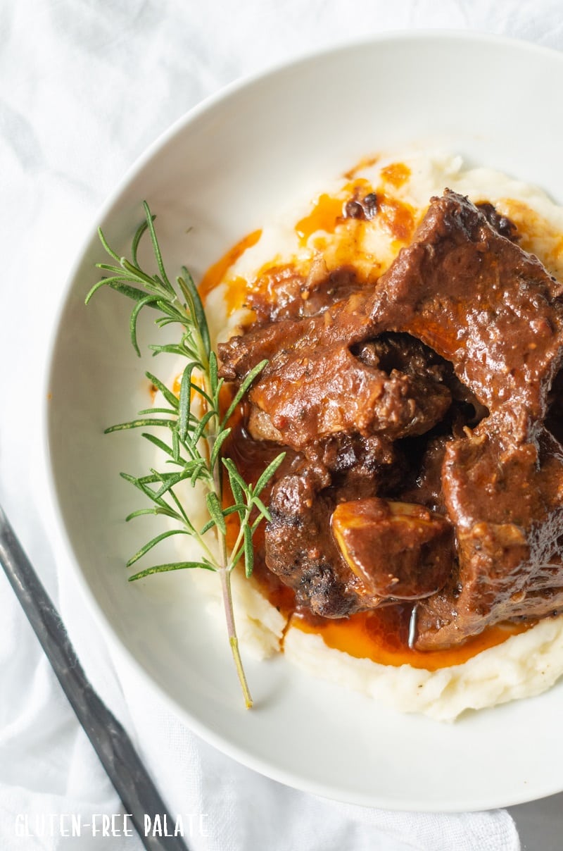 close up top down view of beef short ribs over mashed potatoes