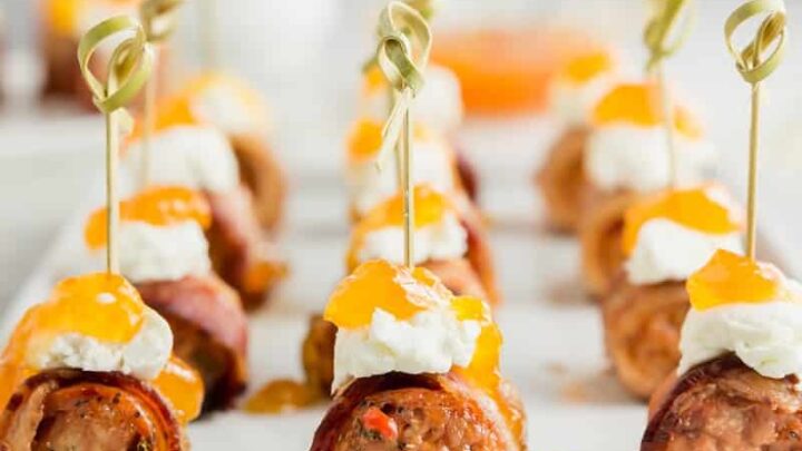 Close up view of sausage appetizers topped with goat cheese