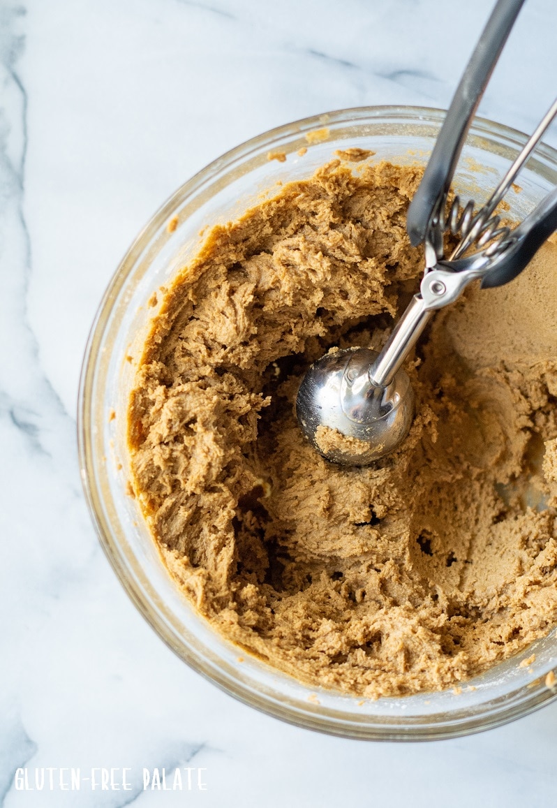 a bowl with gluten free gingersnap cookie dough and a scoop