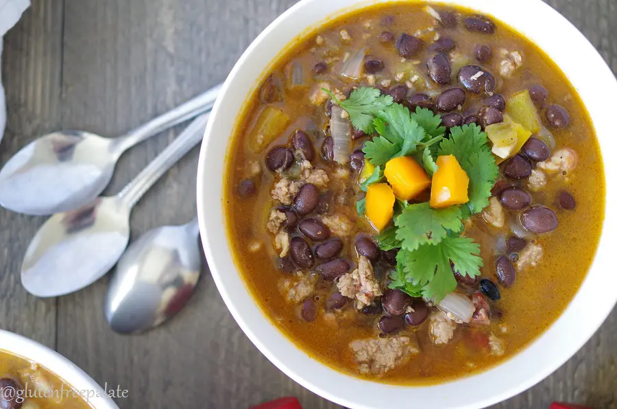 A close up top view of spicy black bean soup topped with cilantro