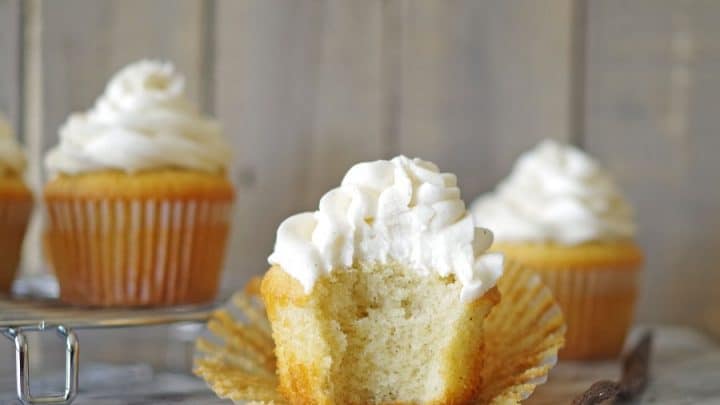 a gluten free vanilla bean cupcake with a bite out of it on a marble counter