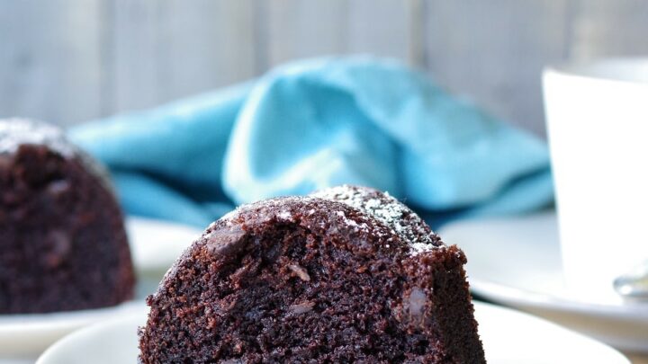 a slice of Gluten-Free Chocolate Bundt Cake on a white plate next to a fork