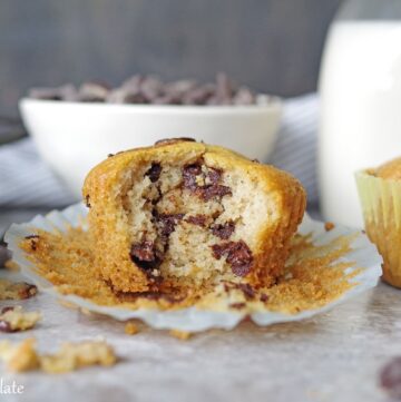 a paleo chocolate chip muffin with a bite out showing the chocolate chips inside