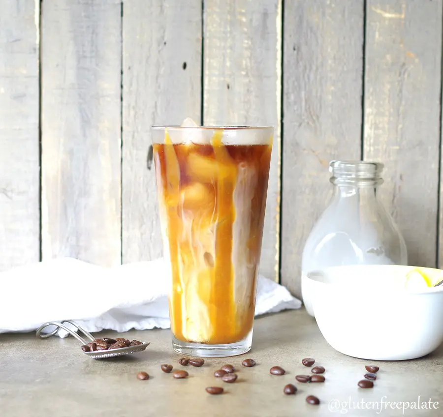 Homemade iced coffee in a glass with caramel and coffee beans