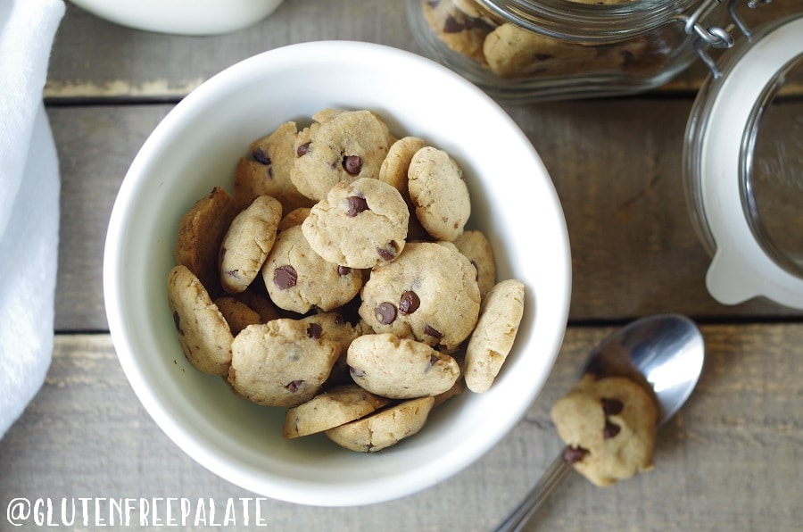 a close up of gluten free vegan cereal in the shape of chocolate chips cookies in a white bowl