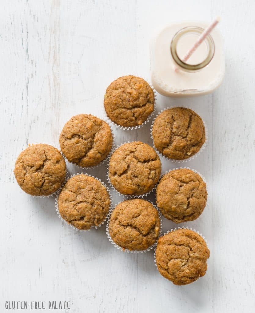 Gluten free honey flaxseed muffins arranged next to a jar of milk with a straw
