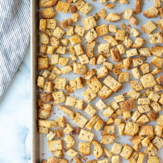 a top down view of cooked gluten-free croutons on a baking sheet