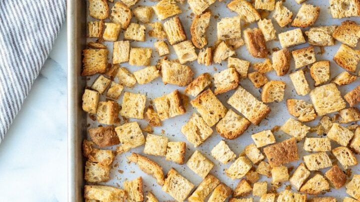 a top down view of cooked gluten-free croutons on a baking sheet