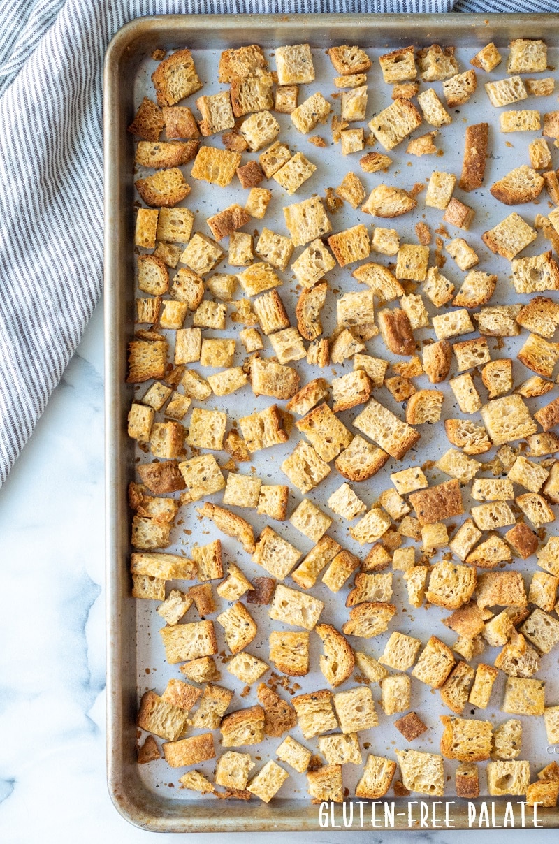 a top down view of cooked gluten free croutons on a baking sheet