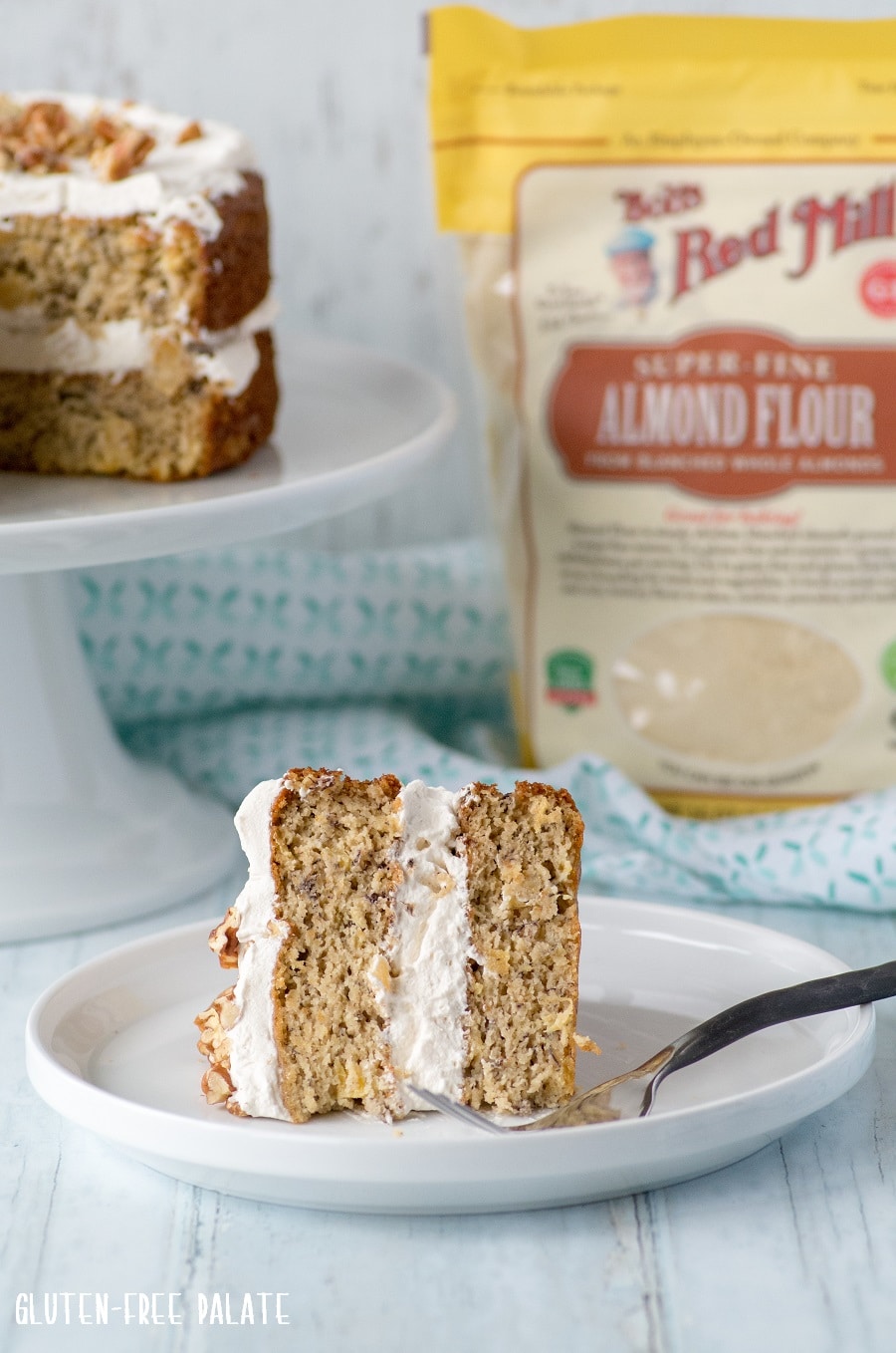 slice of Grain-Free Hummingbird Cake on a white plate with a fork