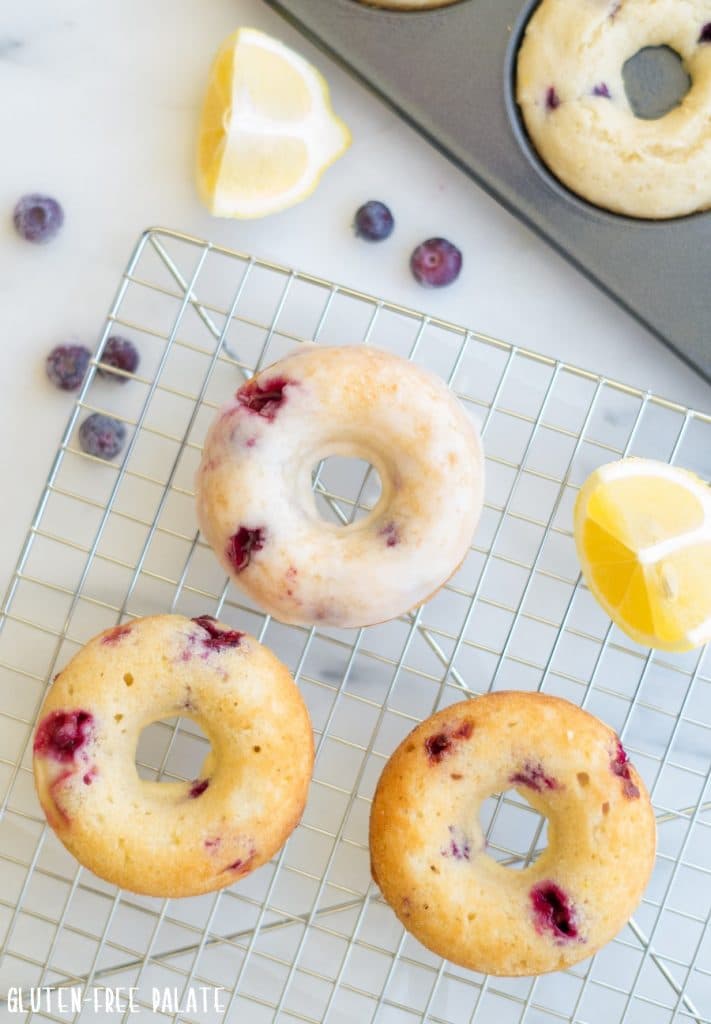 Gluten-Free Blueberry Donuts with a glaze on a wire rack