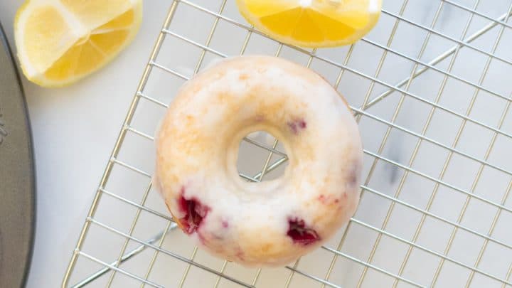 a close up of Gluten-Free Blueberry Donuts with a glaze on a wire rack
