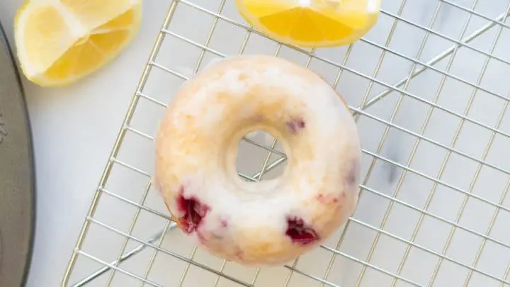 a close up of Gluten-Free Blueberry Donuts with a glaze on a wire rack