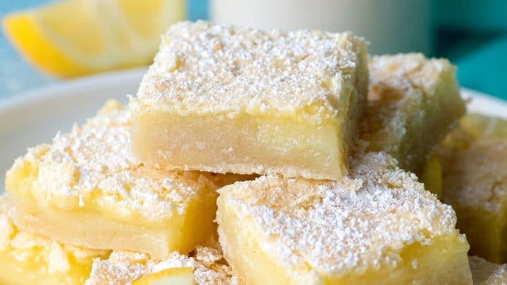 stack of Gluten-Free Lemon Bars topped with powdered sugar on a white plate