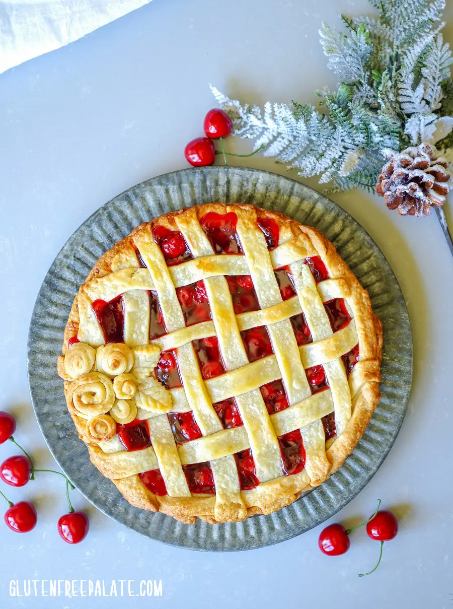 gluten-free cherry pie with a weaved top crust and pie crust flowers