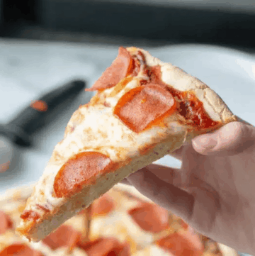 A slice of Gluten-free pizza showcasing the chewy crust.