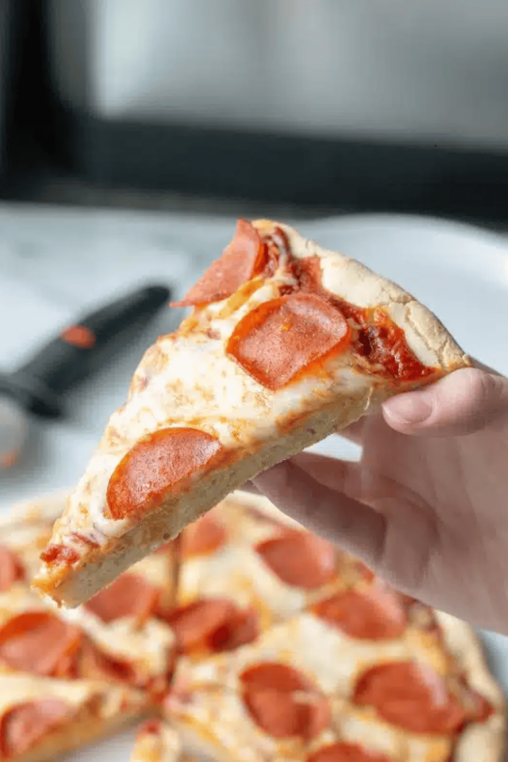 A slice of Gluten-free pizza showcasing the chewy crust.