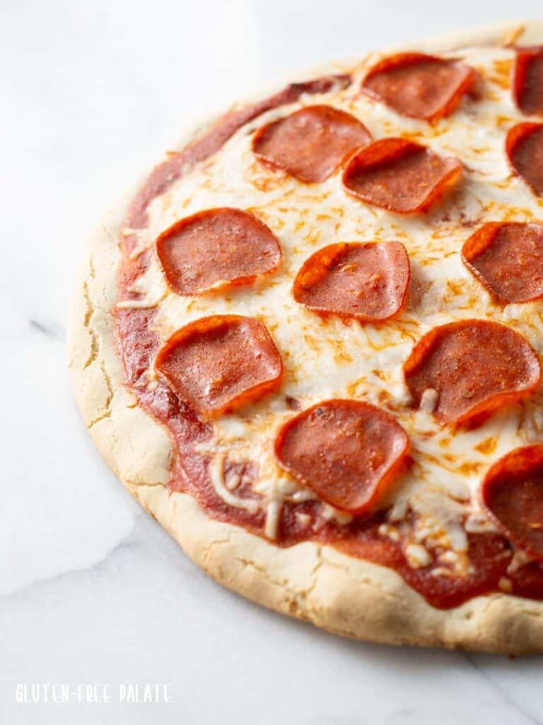 A close up of a Gluten Free Pizza topped with cheese and pepperoni.