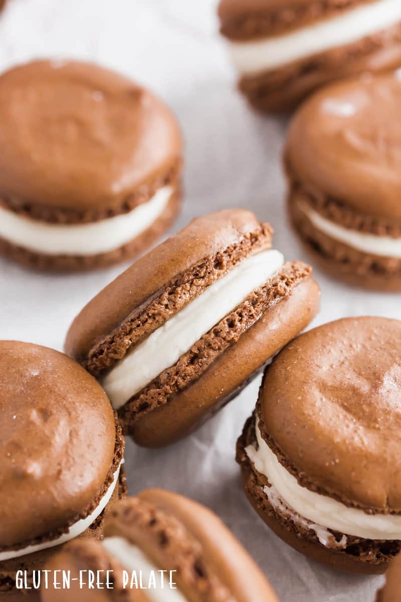 a side view of a gluten free chocolate macaron with white frosting in the center