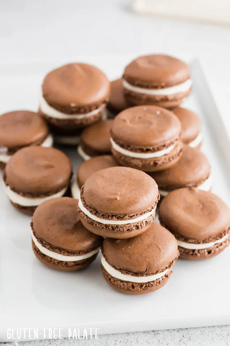 a stack of gluten free macarons with white frosting in the center