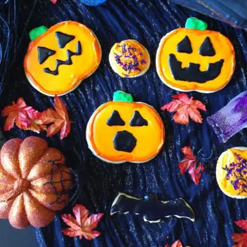 a close up of gluten-free sugar cookies decorated like pumpkins for Halloween