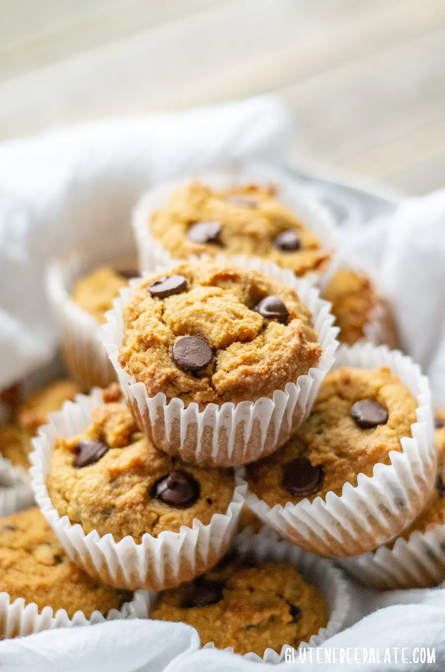 side view of paleo pumpkin muffins with chocolate chips, in a bowl