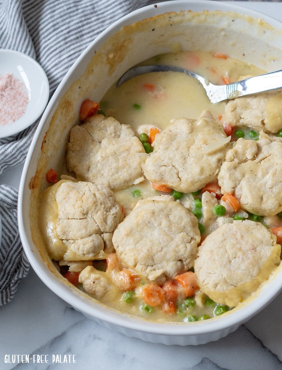 pan full of fresh Gluten-Free Chicken and Biscuits with a serving spoon